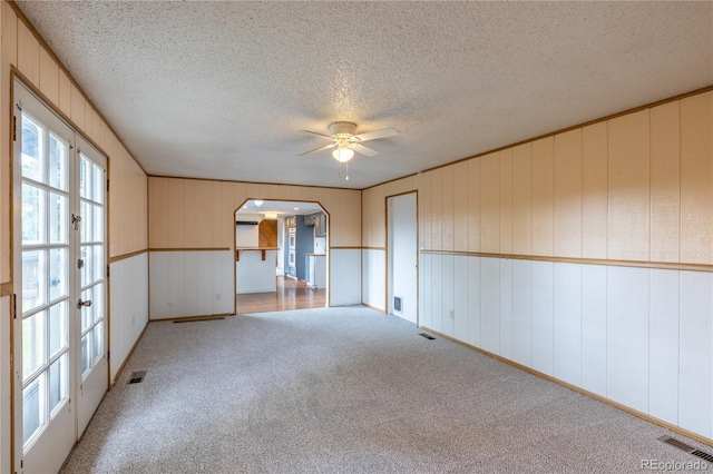 7431 Webster St, Arvada, CO 80003 - carpeted empty room featuring arched walkways, a ceiling fan, a textured ceiling, and french doors