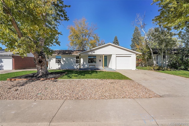 ranch-style house featuring a garage and a front lawn