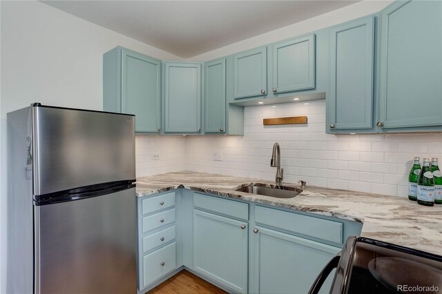 21 N Washington St Unit 301, Denver, CO 80203 - kitchen featuring freestanding refrigerator, blue cabinets, electric range, and light stone countertops