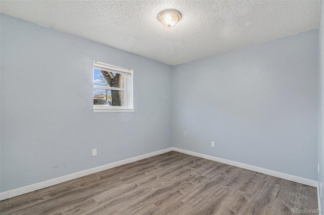 unfurnished room with a textured ceiling and hardwood / wood-style flooring