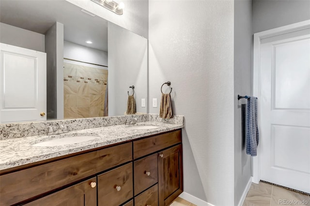 bathroom with tile patterned flooring, vanity, and walk in shower