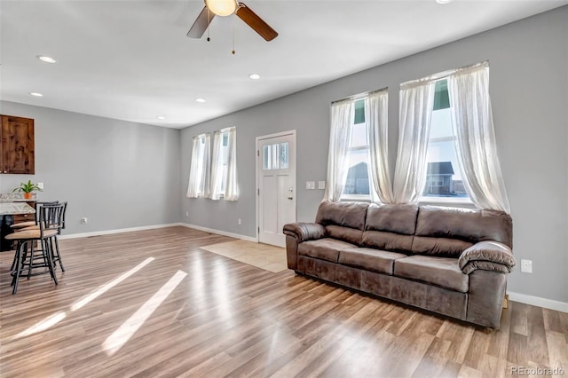 living room featuring light hardwood / wood-style floors and ceiling fan