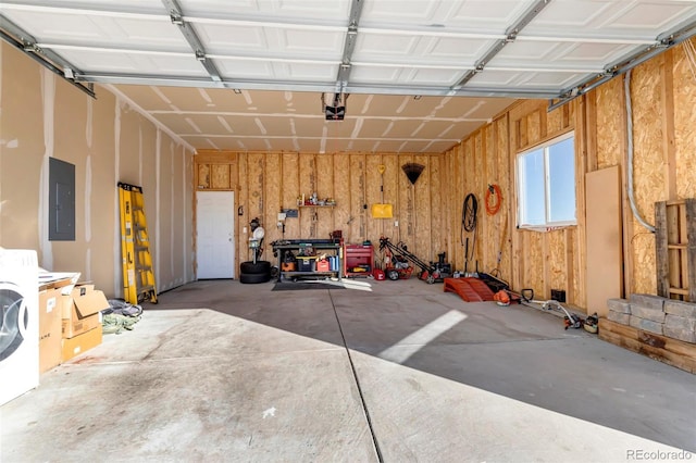 garage with wooden walls, washer / dryer, a garage door opener, and electric panel