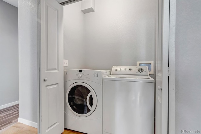 laundry area with separate washer and dryer and light hardwood / wood-style floors