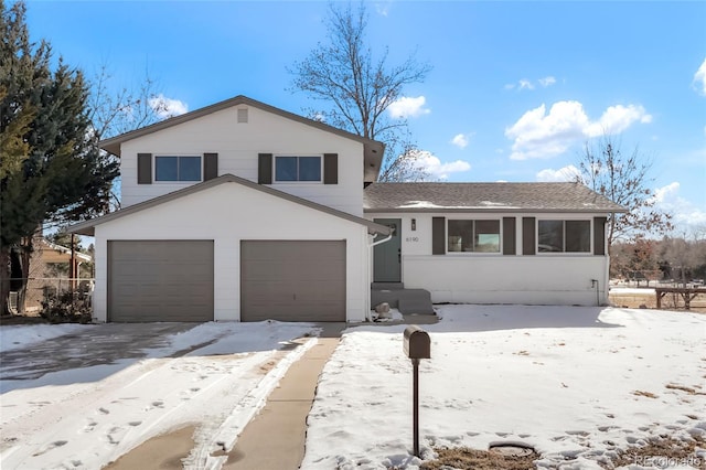 tri-level home with an attached garage and roof with shingles