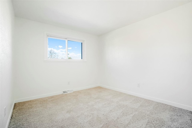 carpeted empty room featuring baseboards and visible vents