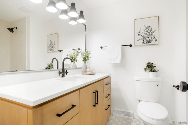 bathroom with toilet, baseboards, visible vents, and vanity