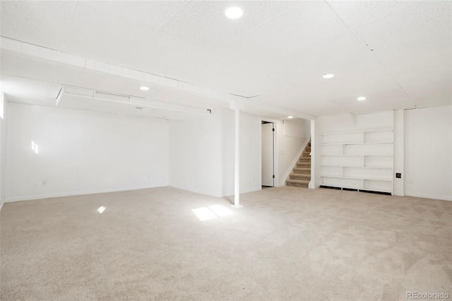 finished basement featuring carpet floors, stairs, and recessed lighting