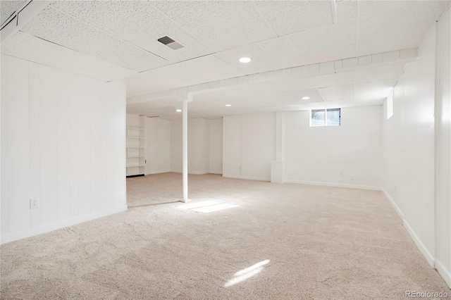 below grade area with carpet, visible vents, and baseboards