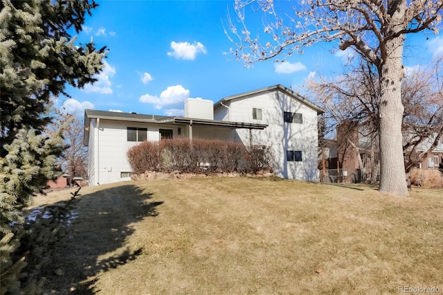 back of property with a yard and a chimney