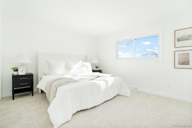 bedroom featuring visible vents, baseboards, and light carpet