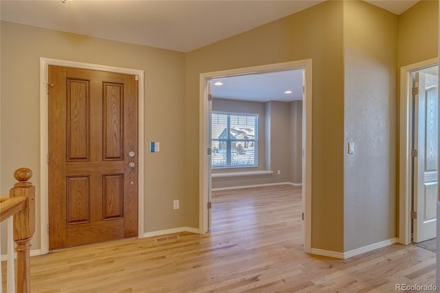 entryway featuring light wood-type flooring and vaulted ceiling