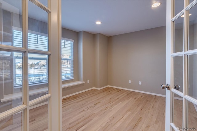 empty room with french doors and light wood-type flooring