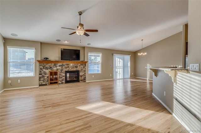 unfurnished living room featuring light wood-type flooring, a wealth of natural light, and a stone fireplace