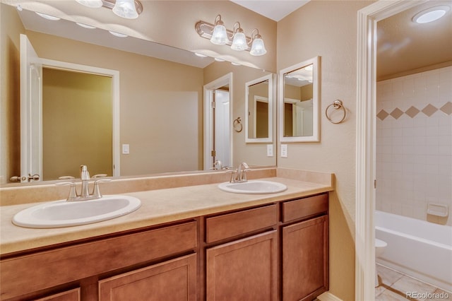 full bathroom with toilet, tiled shower / bath, tile patterned flooring, and vanity