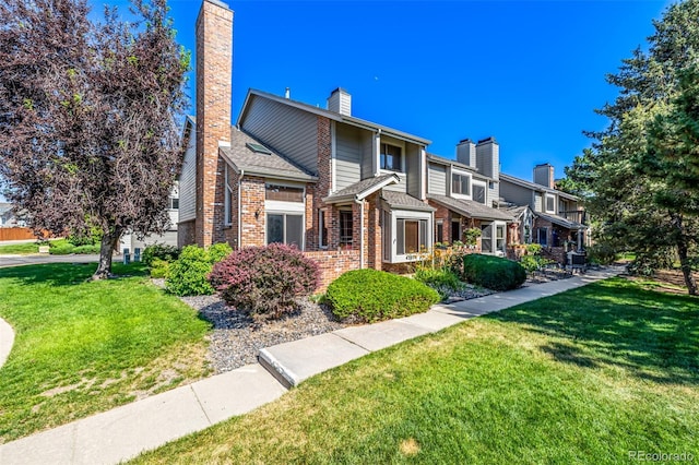 4207 S Granby Ct Unit A, Aurora, CO 80014 - view of front of house featuring a chimney, brick siding, and a front yard
