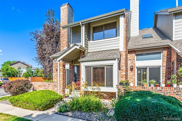 4207 S Granby Ct Unit A, Aurora, CO 80014 - view of front of home with a chimney, brick siding, and a shingled roof