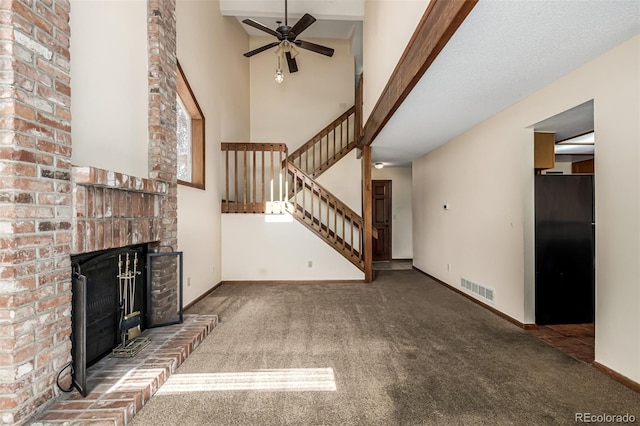 4207 S Granby Ct Unit A, Aurora, CO 80014 - unfurnished living room with stairs, a high ceiling, carpet, a brick fireplace, and a ceiling fan