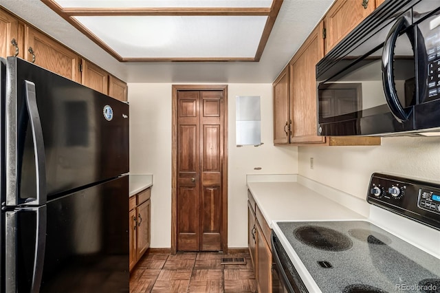 4207 S Granby Ct Unit A, Aurora, CO 80014 - kitchen with black appliances, brown cabinetry, and light countertops