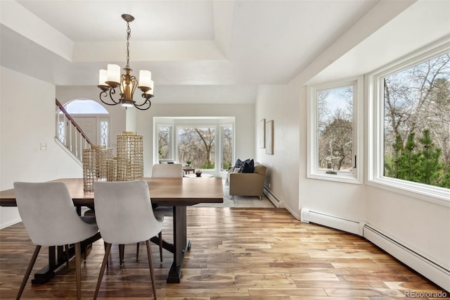 14536 Latrobe Dr, Colorado Springs, CO 80921 - dining space featuring a tray ceiling, a baseboard radiator, a chandelier, and light wood-type flooring