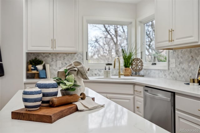 14536 Latrobe Dr, Colorado Springs, CO 80921 - kitchen featuring stainless steel dishwasher, a sink, decorative backsplash, white cabinets, and light countertops
