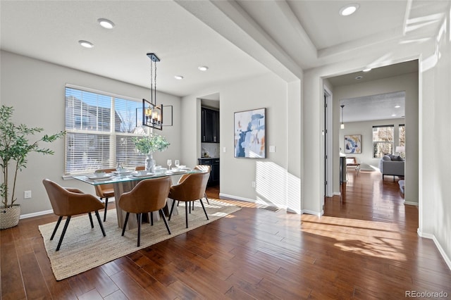 dining area featuring dark hardwood / wood-style flooring and an inviting chandelier