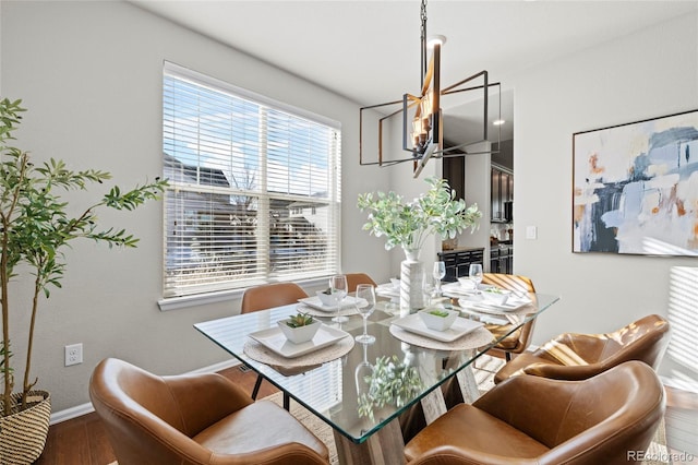 dining area featuring hardwood / wood-style floors and an inviting chandelier