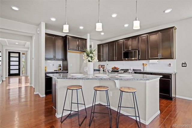 kitchen featuring a center island with sink, dark hardwood / wood-style flooring, and stainless steel appliances