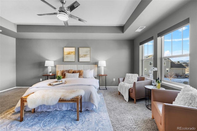 bedroom featuring carpet, ceiling fan, and a tray ceiling