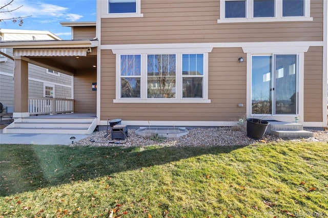 rear view of property featuring a lawn