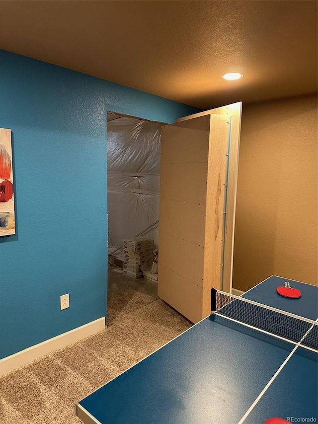 game room with a textured ceiling and carpet floors