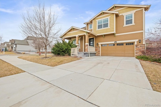 craftsman inspired home featuring a garage, covered porch, stone siding, and driveway