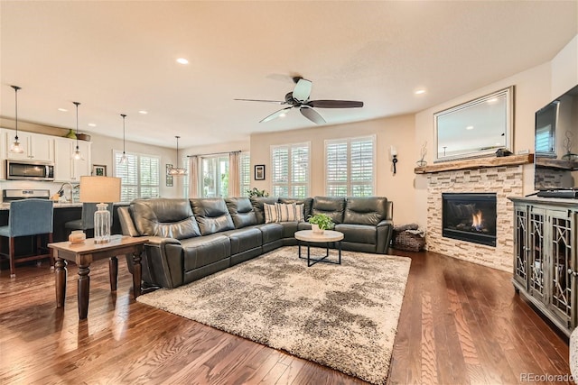 living area featuring a ceiling fan, recessed lighting, a fireplace, and dark wood finished floors