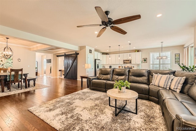 living room featuring a barn door, baseboards, dark wood-style flooring, ceiling fan with notable chandelier, and recessed lighting