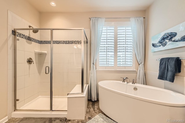 full bathroom with a freestanding tub and a shower stall