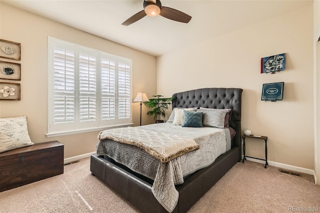 carpeted bedroom featuring ceiling fan, visible vents, and baseboards