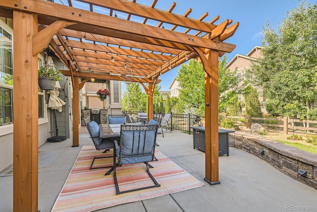 view of patio featuring outdoor dining space, fence, a fire pit, and a pergola