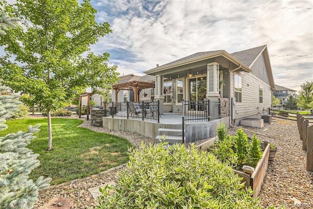 rear view of property featuring board and batten siding, a lawn, and a pergola