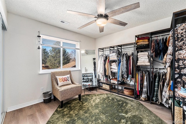 walk in closet featuring ceiling fan, visible vents, and wood finished floors