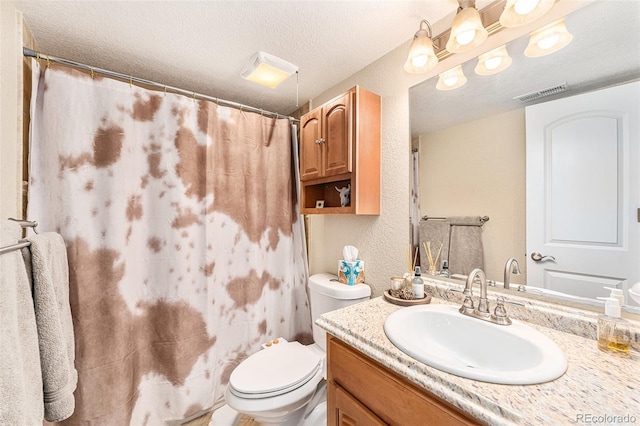 bathroom featuring vanity, visible vents, a textured ceiling, toilet, and a textured wall