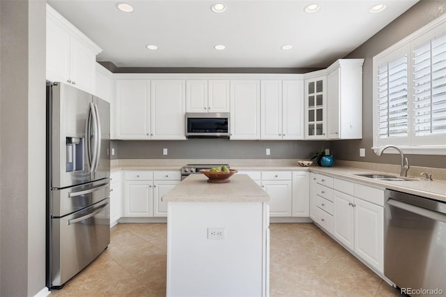10978 Ashurst Ln, Highlands Ranch, CO 80130 - kitchen with appliances with stainless steel finishes, light countertops, white cabinetry, a center island, and glass insert cabinets