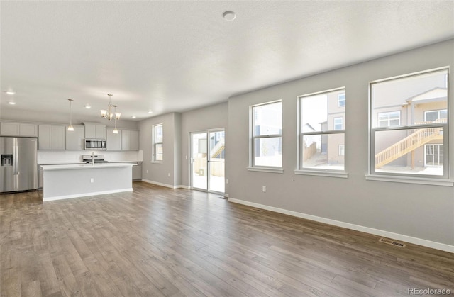 14249 Beebalm Ave, Parker, CO 80134 - unfurnished living room featuring baseboards, dark wood-style flooring, a sink, and recessed lighting