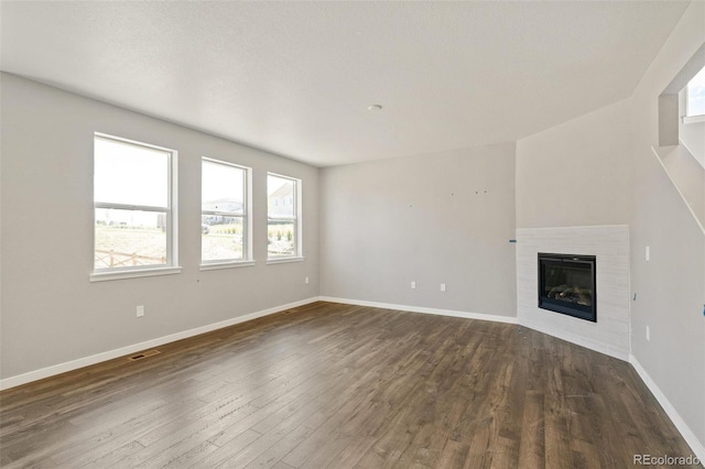 14249 Beebalm Ave, Parker, CO 80134 - unfurnished living room with dark wood-type flooring, baseboards, and a tiled fireplace