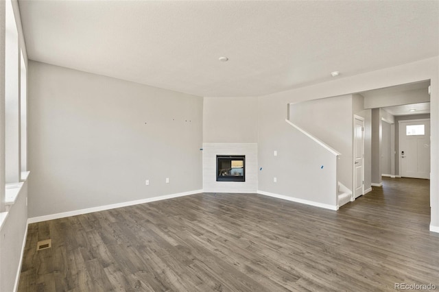 14249 Beebalm Ave, Parker, CO 80134 - unfurnished living room with dark wood finished floors, baseboards, and stairway