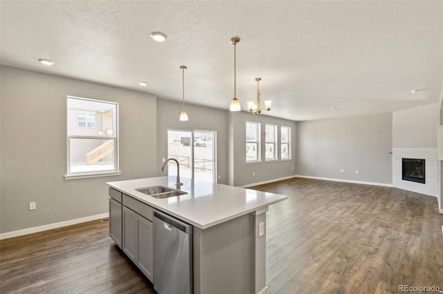 14249 Beebalm Ave, Parker, CO 80134 - kitchen featuring stainless steel dishwasher, a sink, gray cabinetry, baseboards, and dark wood-style floors