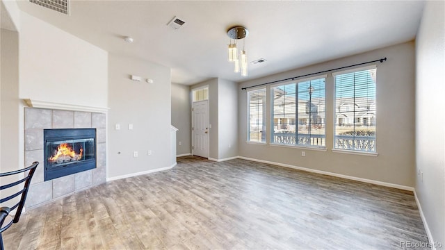 16047 E Geddes Ln Unit 128, Aurora, CO 80016 - unfurnished living room featuring wood finished floors, baseboards, and a tile fireplace