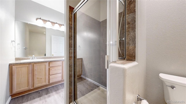 16047 E Geddes Ln Unit 128, Aurora, CO 80016 - full bath with a stall shower, toilet, vanity, and wood finished floors