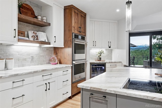 2548 Keystone Dr, Evergreen, CO 80439 - kitchen featuring open shelves, beverage cooler, stainless steel double oven, black electric stovetop, and light stone counters