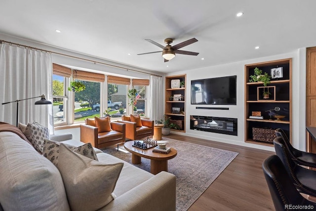 7633 S Gilpin Ct, Centennial, CO 80122 - living area with a ceiling fan, built in shelves, recessed lighting, wood finished floors, and a glass covered fireplace