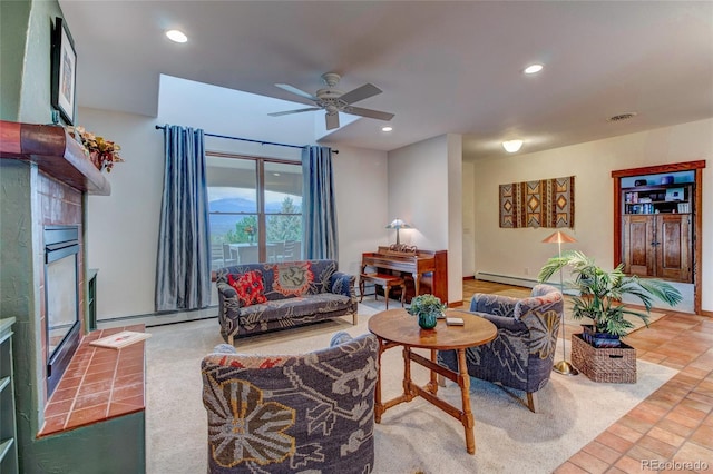 living room featuring tile patterned floors, a tile fireplace, and ceiling fan